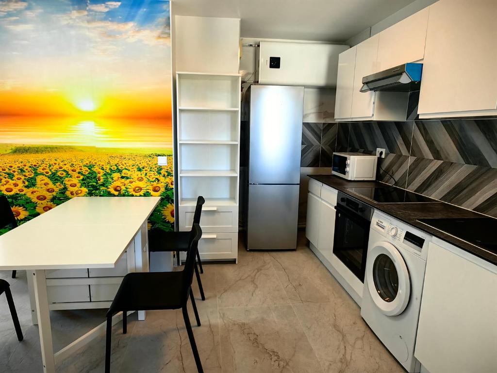 een keuken met een zonnebloem schilderij op de muur bij Spacieux 2 pièces proche plage in Antibes