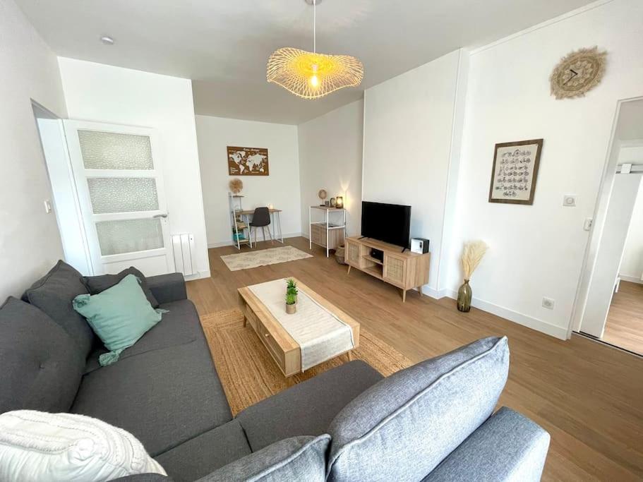 a living room with a couch and a table at Appartement centre-bourg de Bessines in Bessines-sur-Gartempe