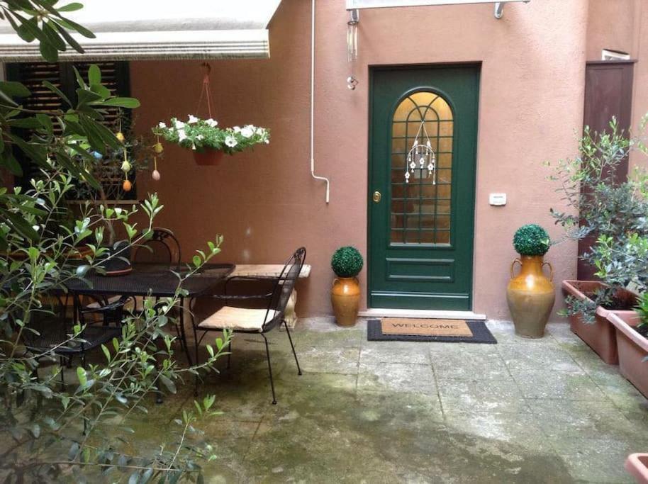 a green door of a house with a table and chairs at Karol Apartment Rome in Rome