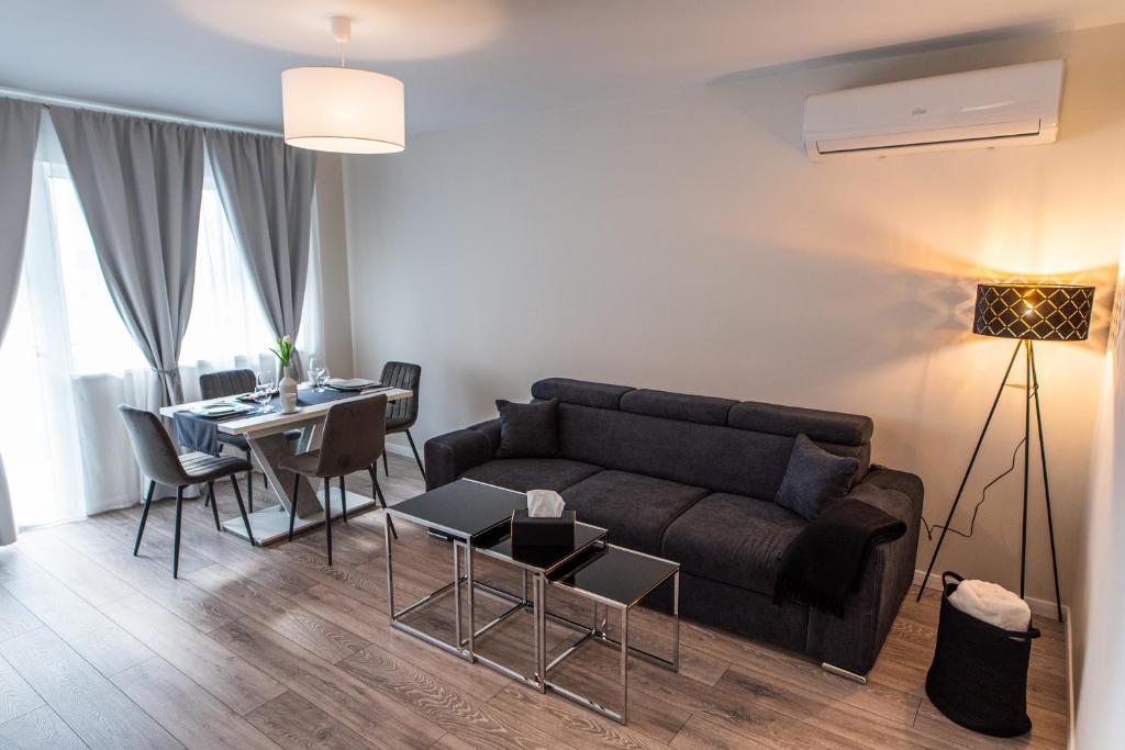 a living room with a couch and a table at TEILOR Apartments 1 in Floreşti