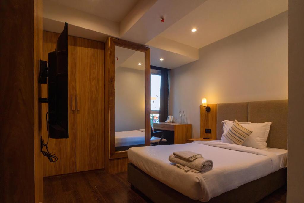 una camera da letto con un letto e asciugamani di Emerald Hotel ad Āīzawl