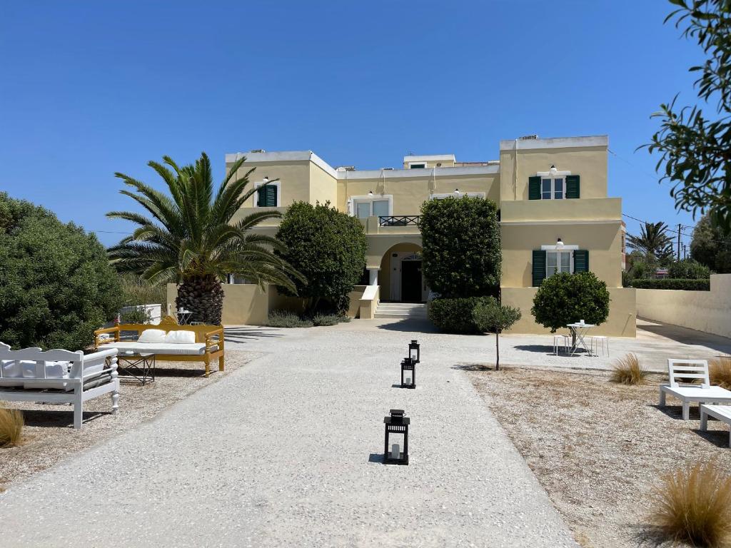 a large building with white benches and a courtyard at Giosifaki in Vari