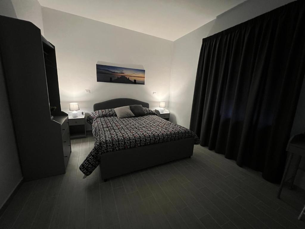 um quarto com uma cama e uma televisão em Affittacamere Gess em Montalto Uffugo