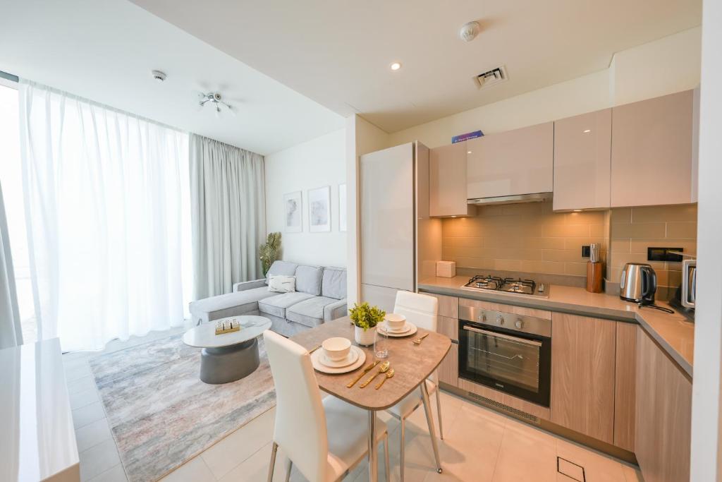 una cucina e un soggiorno con tavolo e sedie di Bright Apartment With Panoramic CityScape Views a Dubai