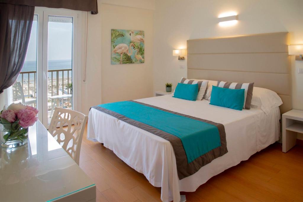 a bedroom with a large bed and a balcony at Hotel Mon Cheri in Riccione