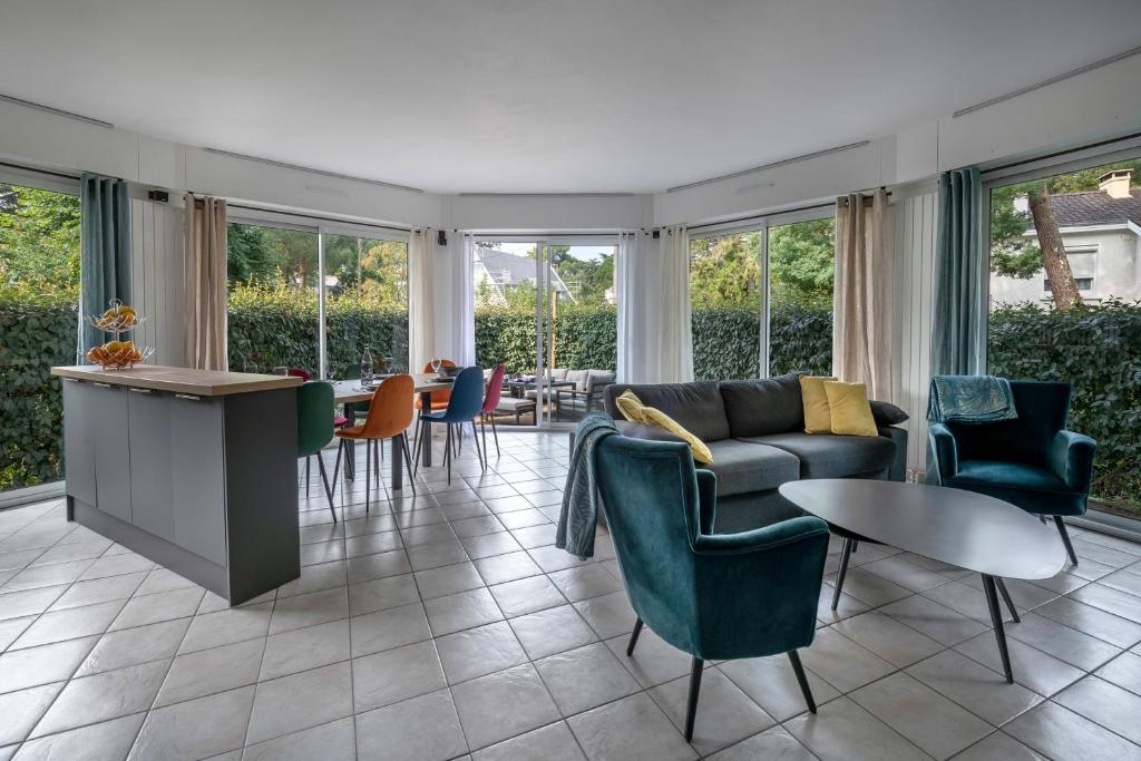 un salon avec un canapé, des chaises et une table dans l'établissement Appartement cosy et moderne à la Baule-Escoublac, à La Baule