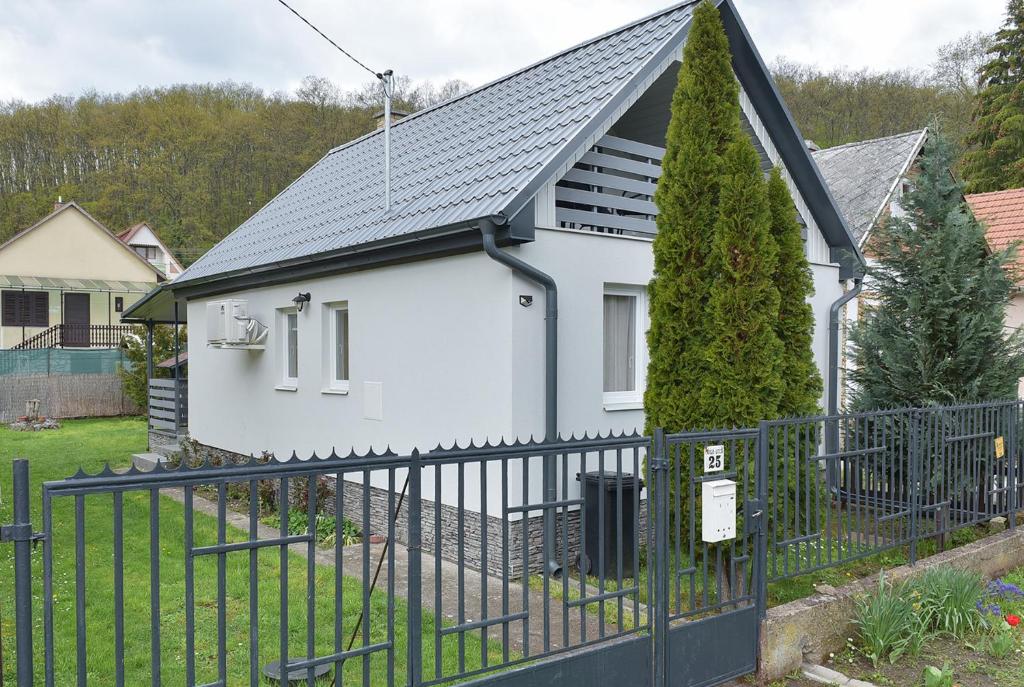 une maison blanche avec une clôture noire dans l'établissement Singh Kuckó Bogács, à Bogács