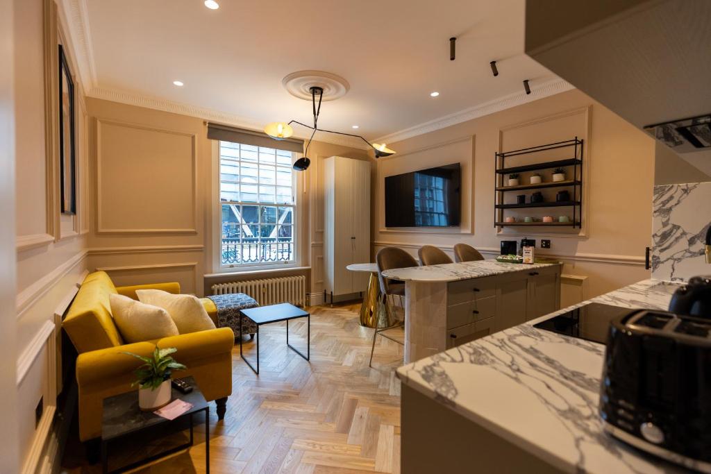 eine Küche und ein Wohnzimmer mit einem gelben Sofa in der Unterkunft Boutique Apartment in Camden road in London
