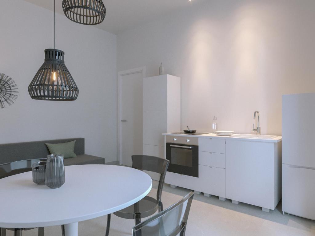 uma cozinha e sala de jantar com uma mesa branca e cadeiras em Fenici Levanzo - Island Apartments em Levanzo