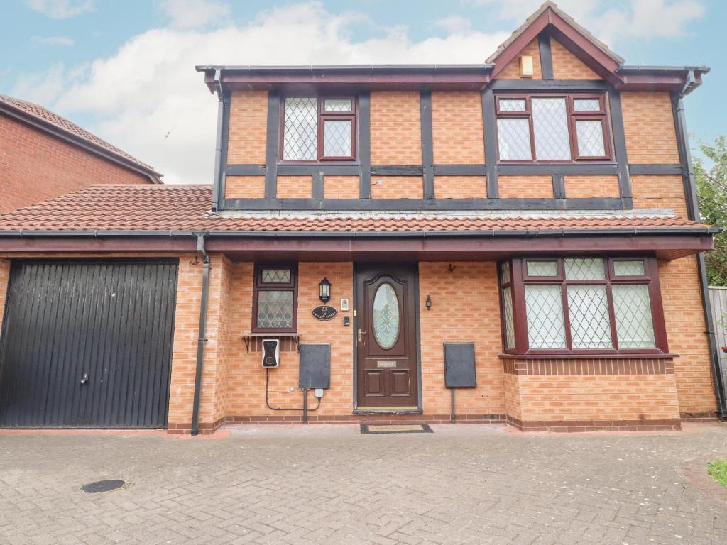 a brick house with a door and a garage at 23 Wolsey Close in Thornton