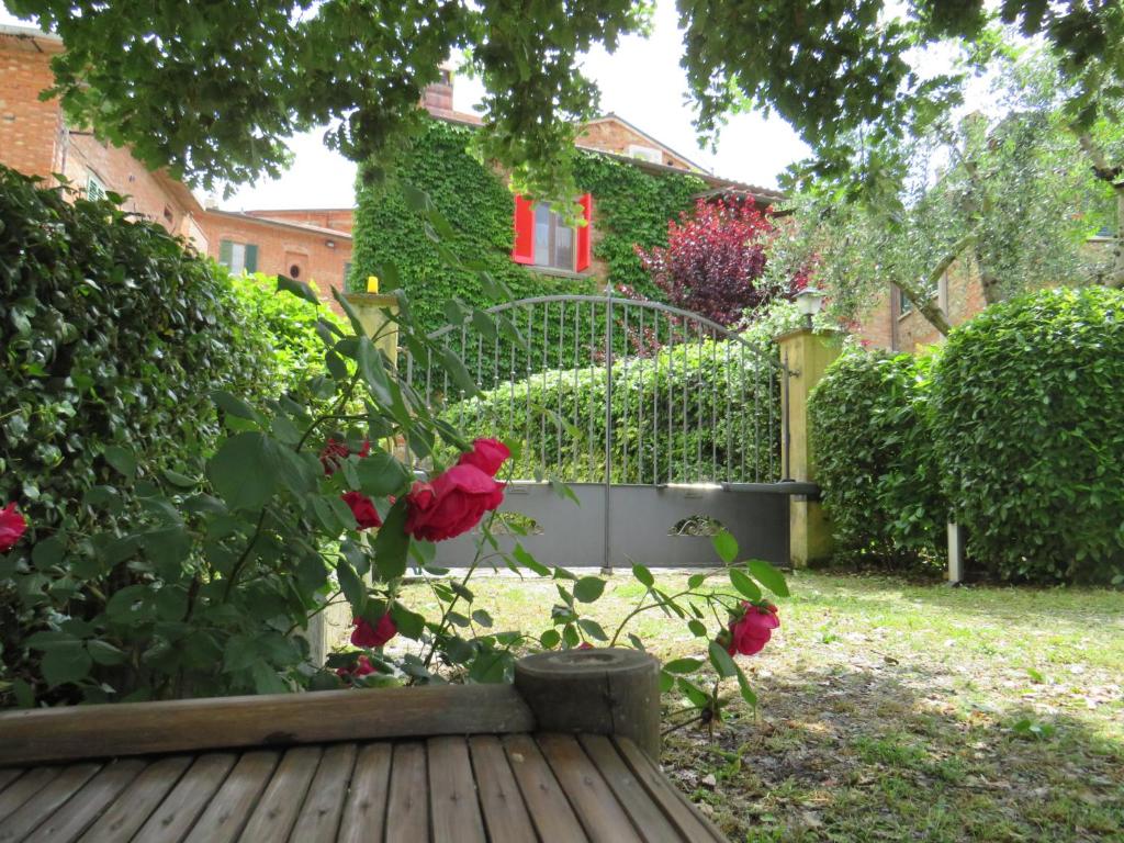 un jardín con rosas rojas y una valla en La Superba Ca' Zeneize, en Foiano della Chiana