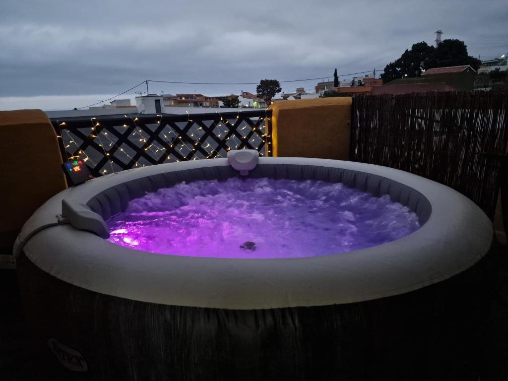 bañera de hidromasaje con agua púrpura en el balcón en Casa Nido, en Icod de los Vinos