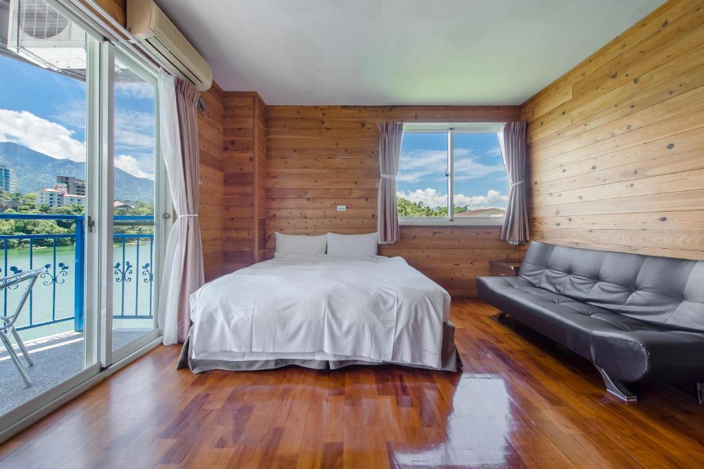 魚池鄉的住宿－碧水山居湖畔民宿，一间卧室配有一张床、一张沙发和窗户。