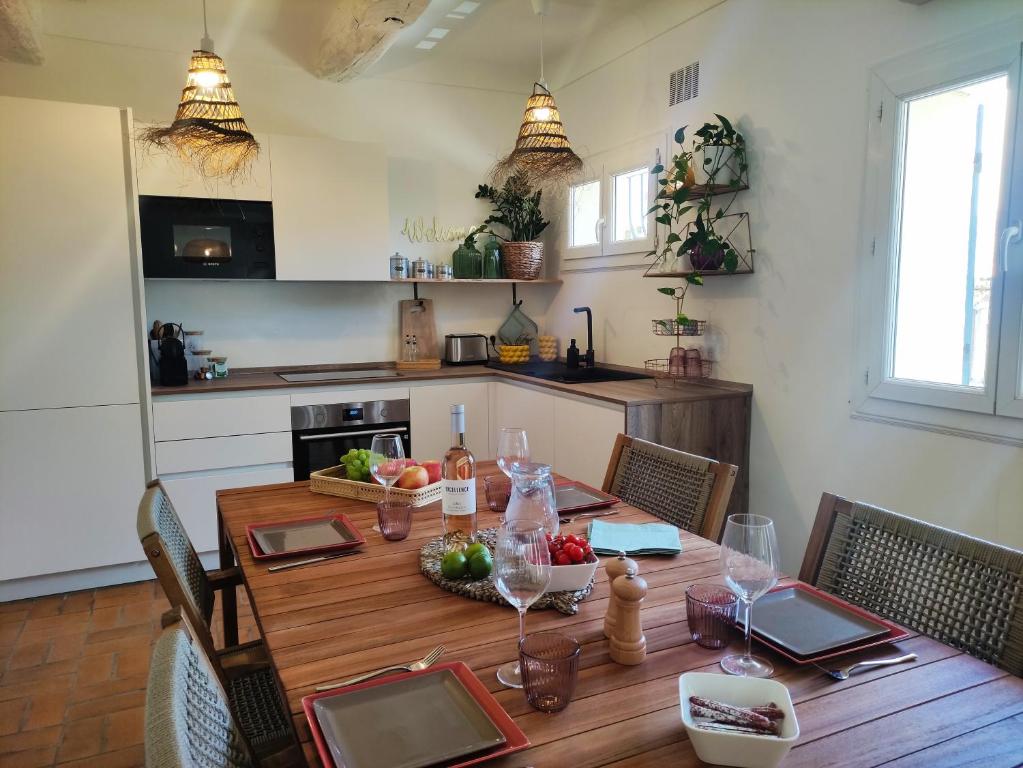 - une cuisine avec une table en bois, des fruits et des verres à vin dans l'établissement Bel Appartement plein centre avec Balcon, clim, au Plan-de-la-Tour