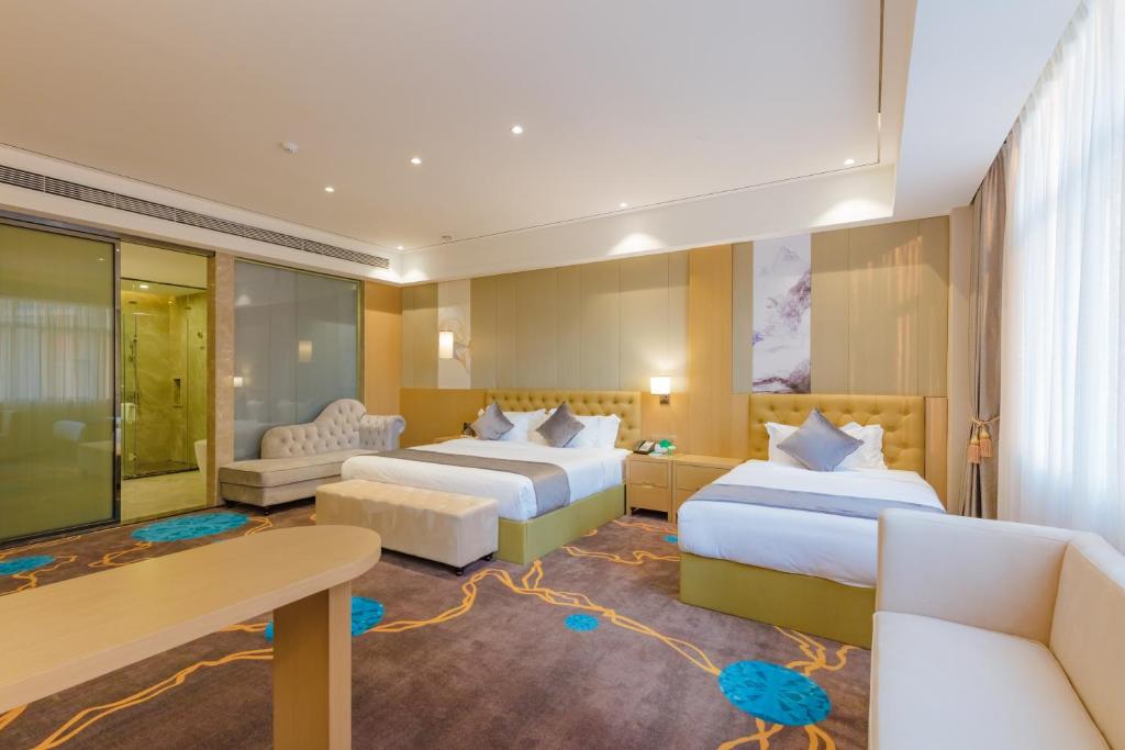 ein Hotelzimmer mit 2 Betten und einem Schreibtisch in der Unterkunft Taishan He Style Hotel in Taishan