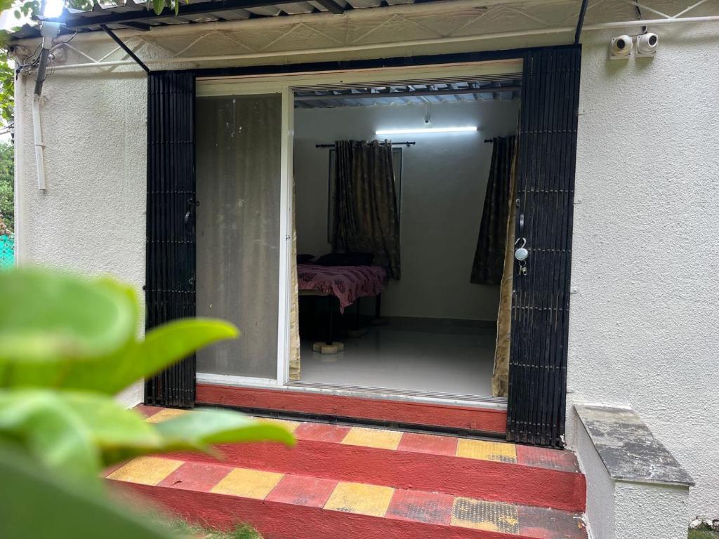 a screened in porch of a house with a bedroom at Private Farm Stay in Pune
