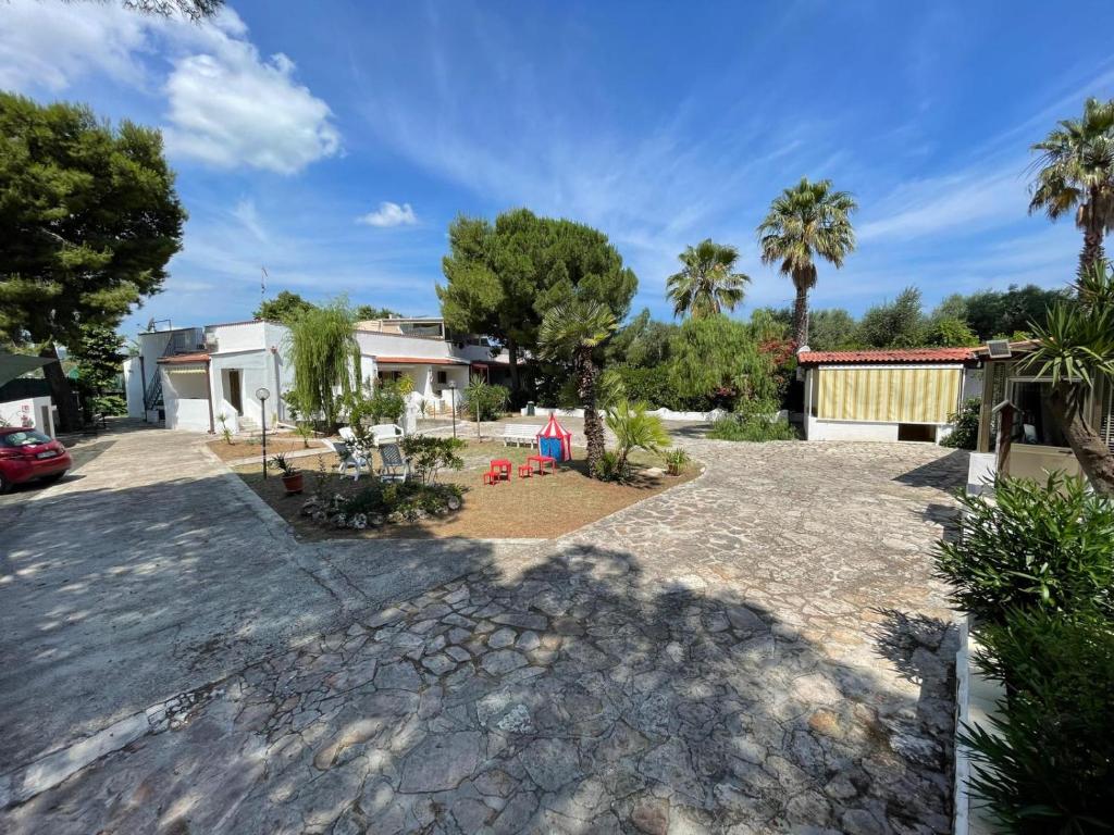 un patio trasero con palmeras y una casa en Le Porte del Gargano, en Vieste