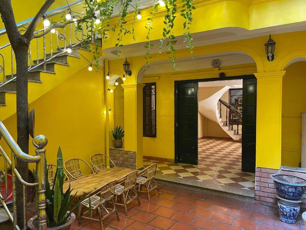 a dining room with yellow walls and a table and chairs at Morri Homestay - Quán Thánh in Hanoi
