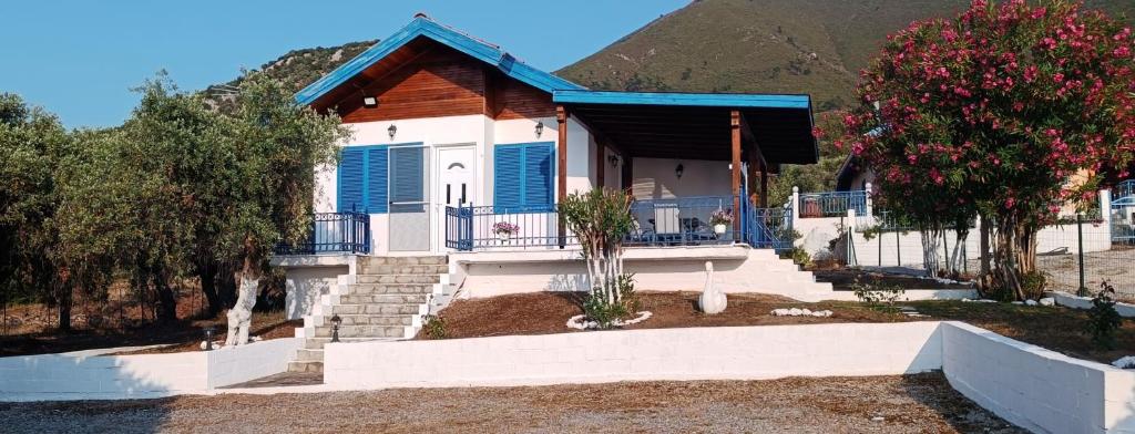 a house with blue shutters and stairs in front of a mountain at Villas Kiriaki in Kallirakhi