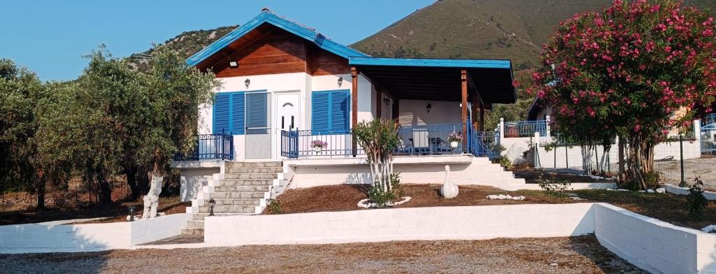 a house with blue shutters and stairs in front of a mountain at Villas Kiriaki in Kallirákhi