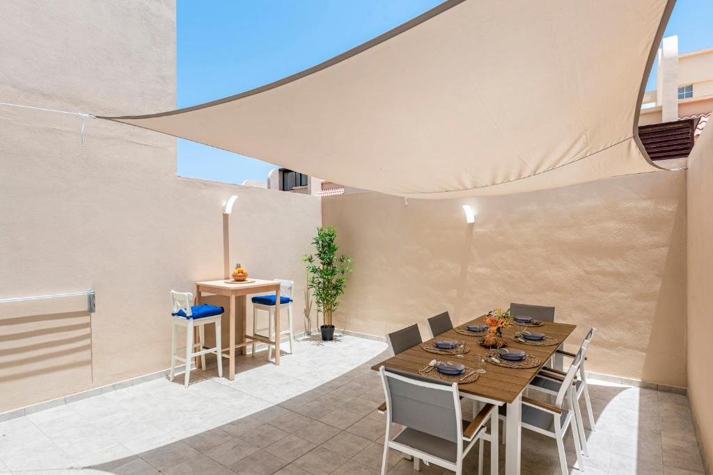 una sala da pranzo con tavolo e sedie di MEDANO4YOU La Jaquita Terrace Holiday Home a El Médano