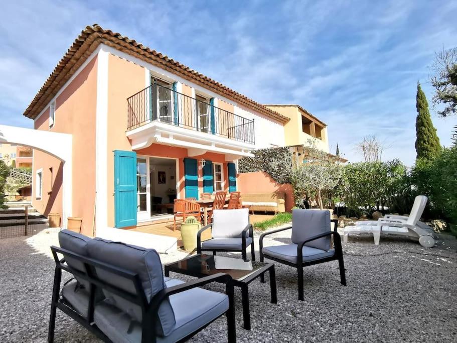 une terrasse avec des chaises et une table en face d'une maison dans l'établissement Maison dans le domaine du golf, à Roquebrune-sur Argens