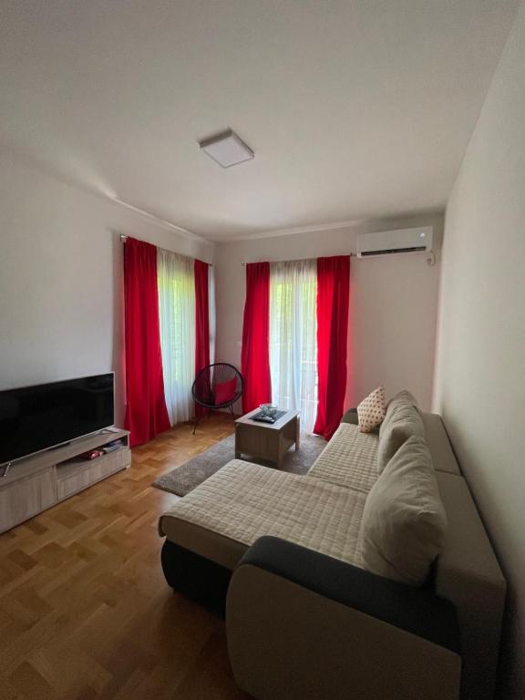 - un salon avec un canapé et des rideaux rouges dans l'établissement Marina, à Budva