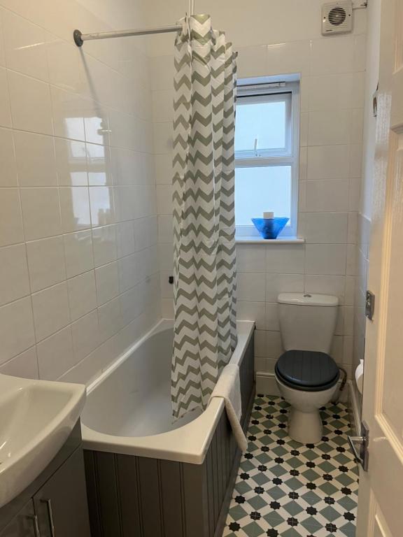 a bathroom with a tub and a toilet and a sink at Flat Beside the sea in Southend-on-Sea