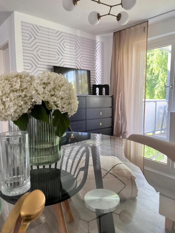 奧芬堡的住宿－Charmantes Apartment，用餐室,配有带花瓶的玻璃桌