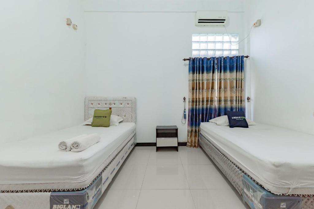 Postel nebo postele na pokoji v ubytování Urbanview Hotel 99 Syariah Banjarbaru by RedDoorz