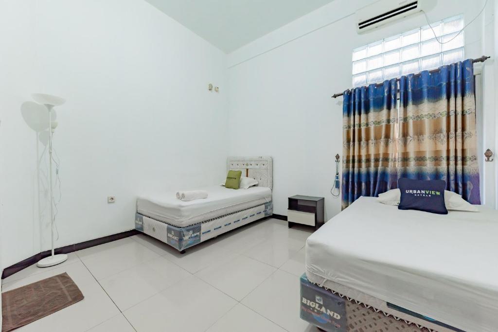 Postel nebo postele na pokoji v ubytování Urbanview Hotel 99 Syariah Banjarbaru by RedDoorz