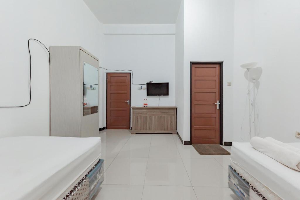 Postel nebo postele na pokoji v ubytování Urbanview Hotel 99 Syariah Banjarbaru by RedDoorz