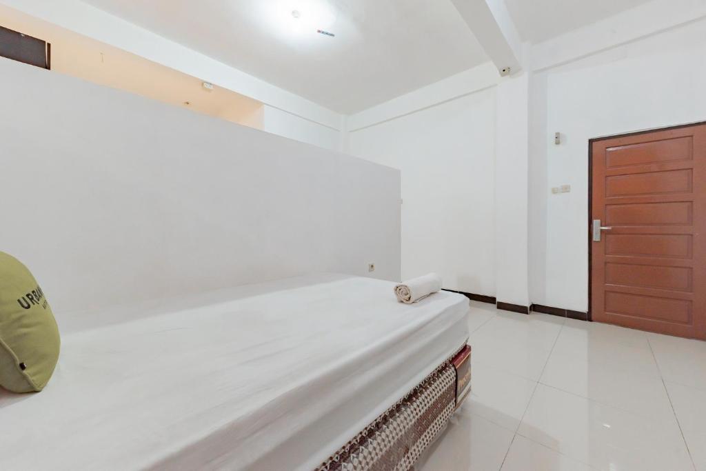 Postel nebo postele na pokoji v ubytování Urbanview Hotel 99 Syariah Banjarbaru by RedDoorz