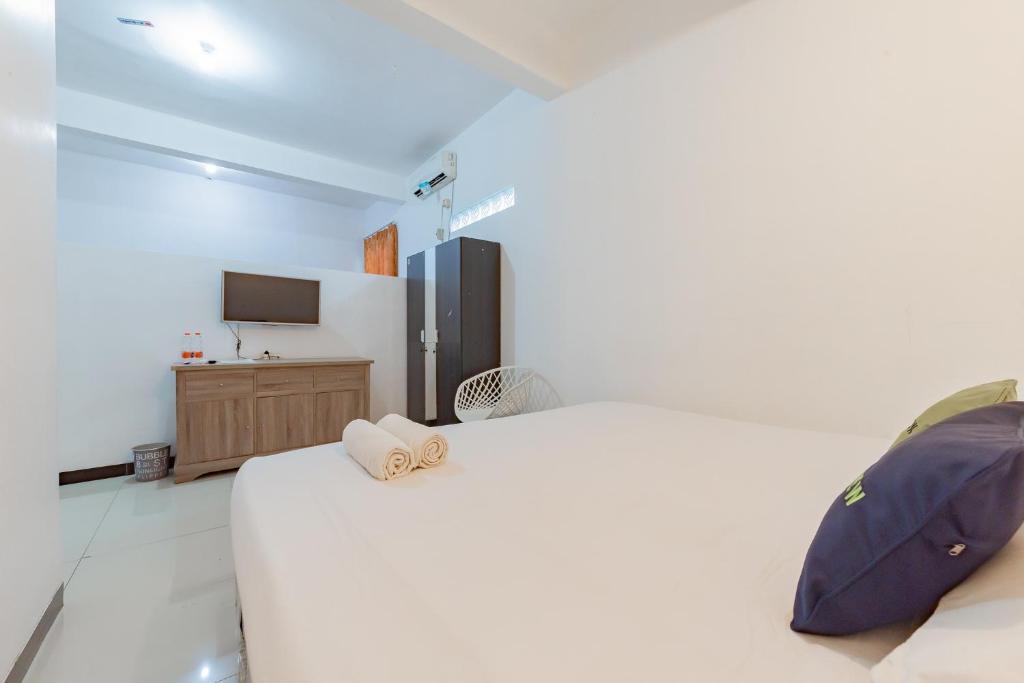 Postel nebo postele na pokoji v ubytování Urbanview Hotel 99 Syariah Banjarbaru by RedDoorz