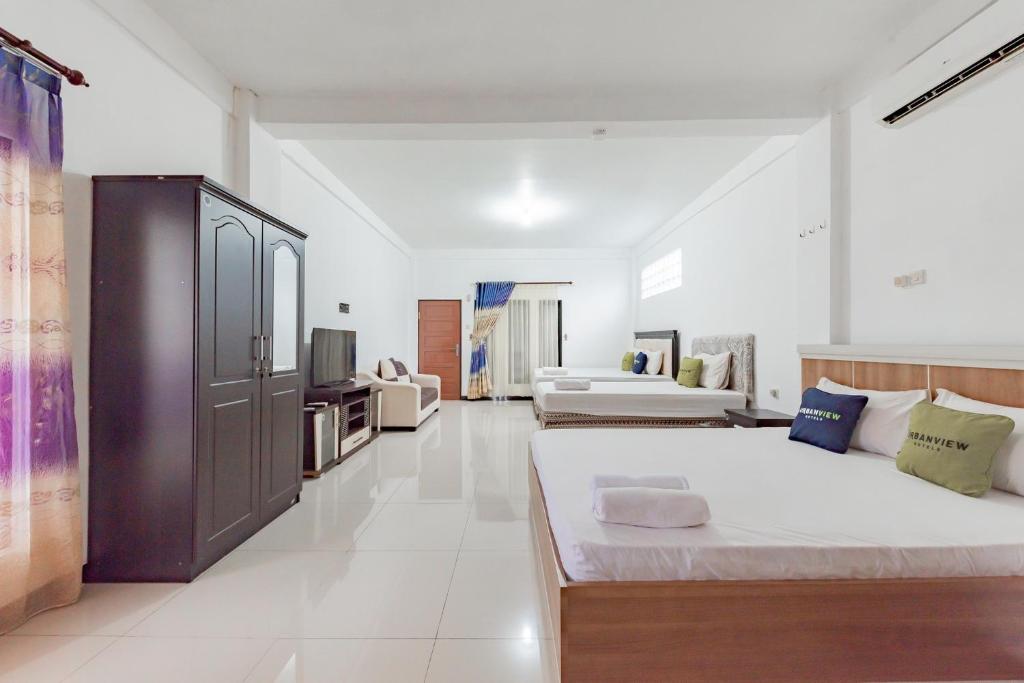 Postel nebo postele na pokoji v ubytování Urbanview Hotel 99 Syariah Banjarbaru by RedDoorz