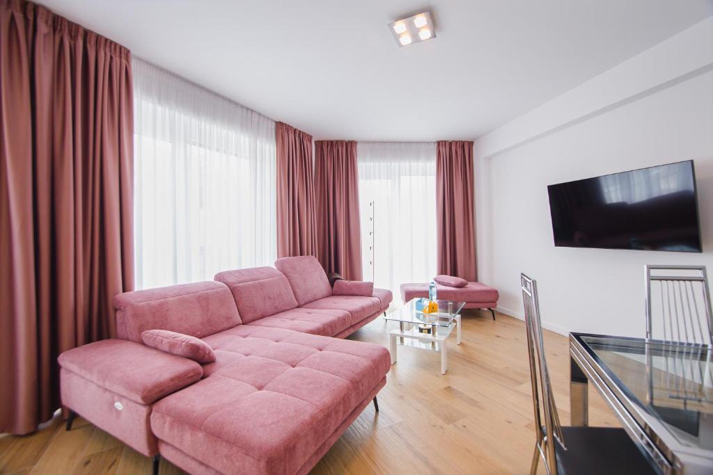 a living room with a pink couch and a table at Pink Sahara near City Center in Oradea