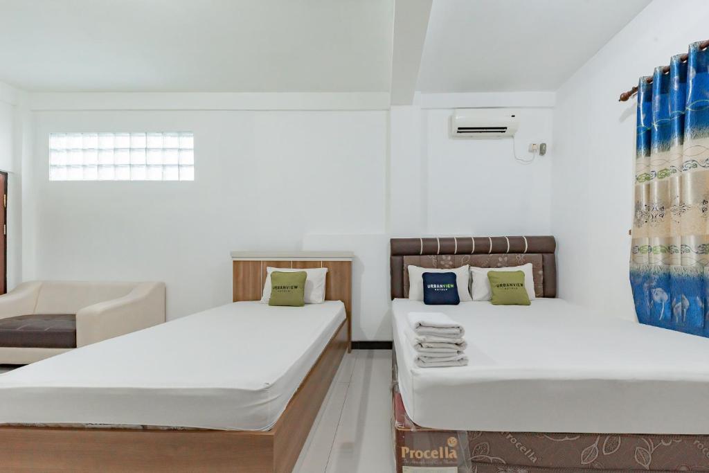 Postel nebo postele na pokoji v ubytování Urbanview Hotel 99 Syariah Banjarbaru by RedDoorz