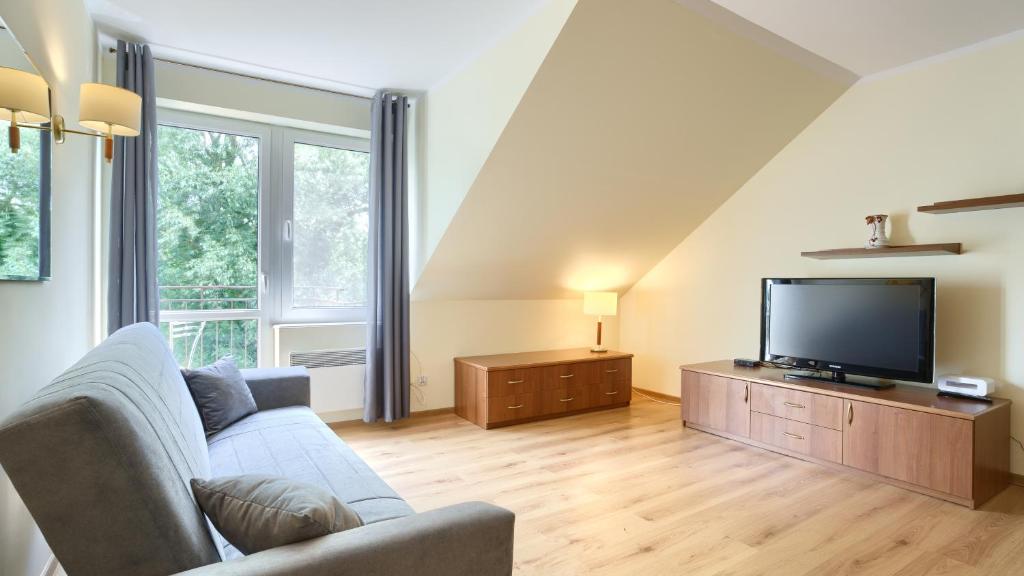 un soggiorno con divano e TV a schermo piatto di Apartamenty Sun & Snow Morskie Oko a Międzyzdroje