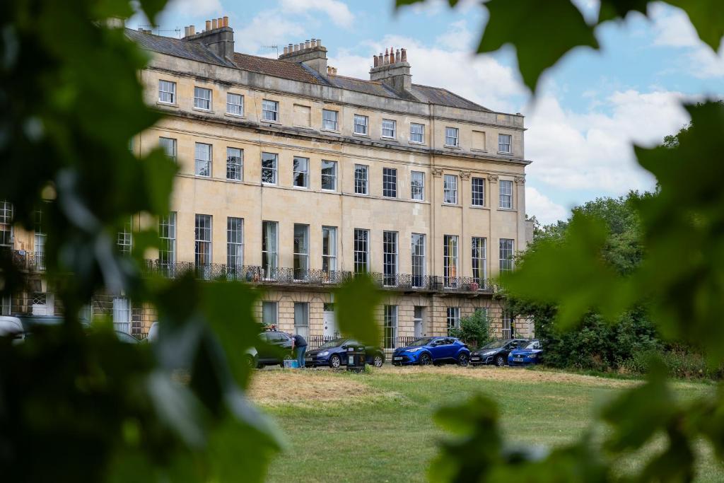 ein großes Gebäude mit davor geparkt in der Unterkunft Crescent Green in Bath