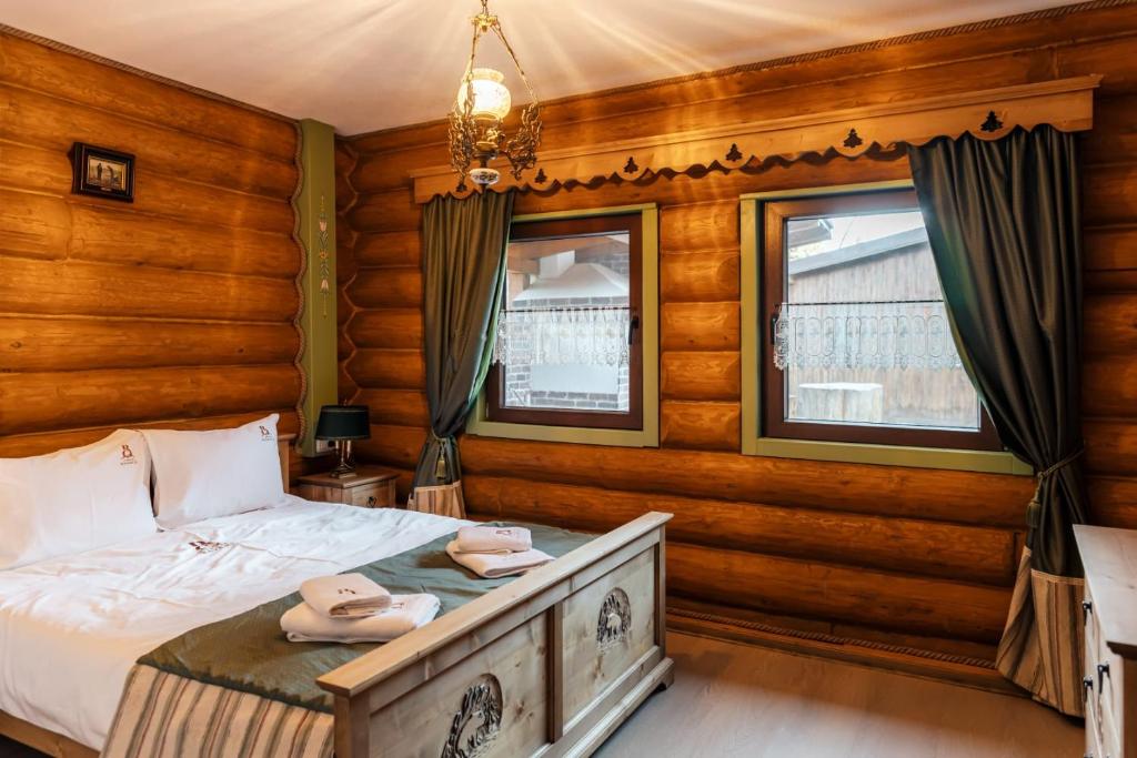 a bedroom with a bed in a room with wooden walls at Cabana Bavareză in Porumbacu de Sus