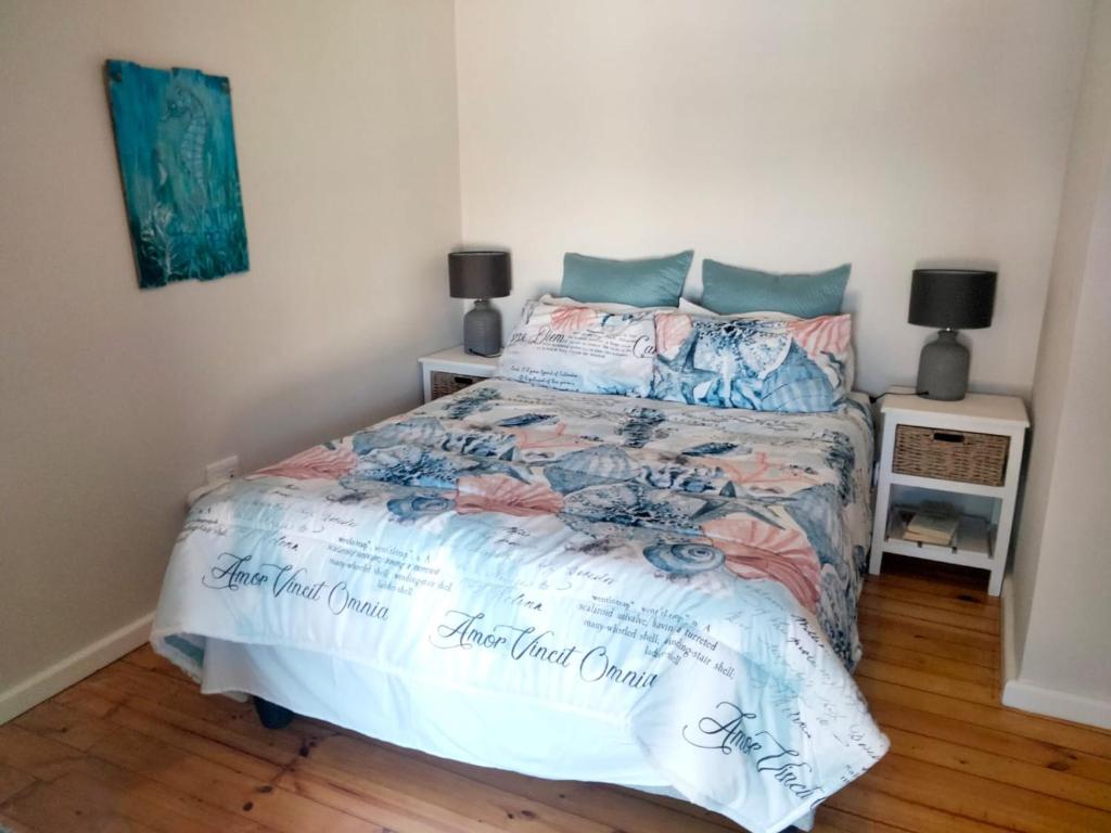 a bedroom with a bed with a comforter on it at Pêrel of Perlemoenbaai in Gansbaai