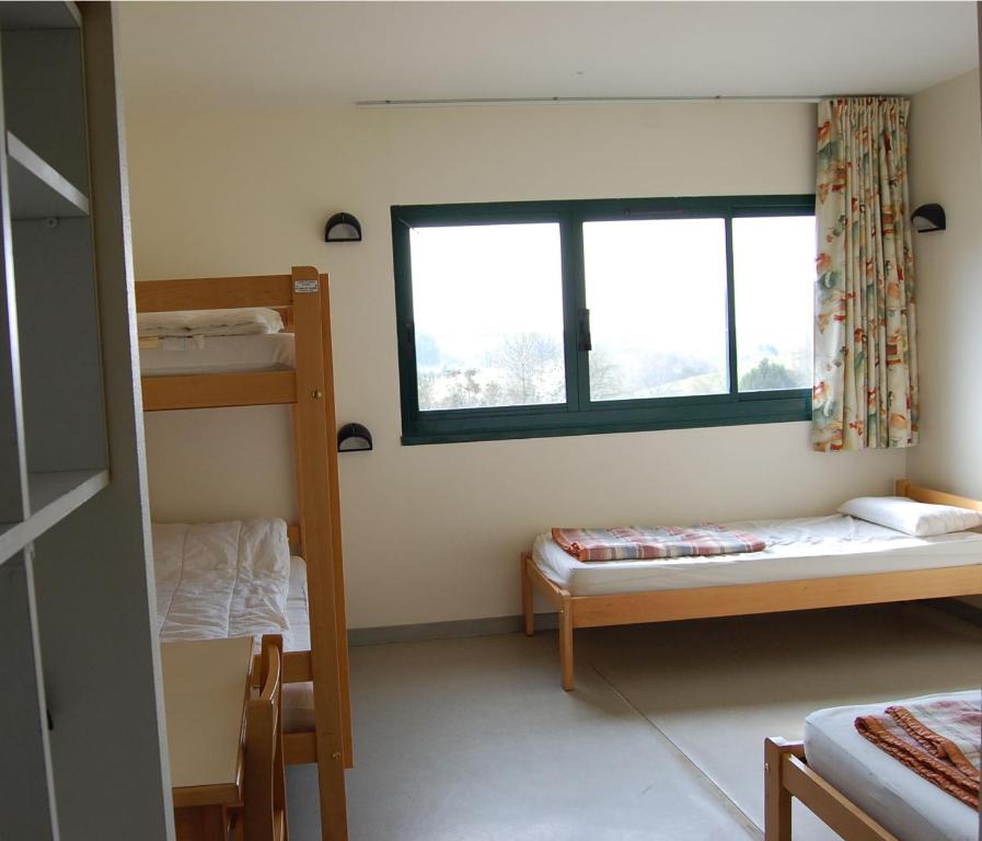 a room with two bunk beds and a window at Ti menez Are in Brasparts