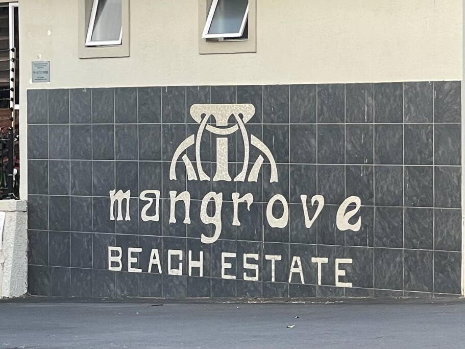 un panneau indiquant un institut de plage sur le côté d'un bâtiment dans l'établissement Paradise By The Beach - 1 Mzimayi, à Port Shepstone