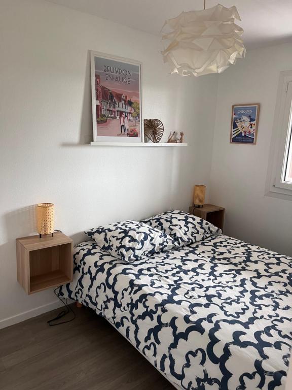 Dormitorio con cama y póster en la pared en Plage Cabourg 7 Vue Mer, en Cabourg