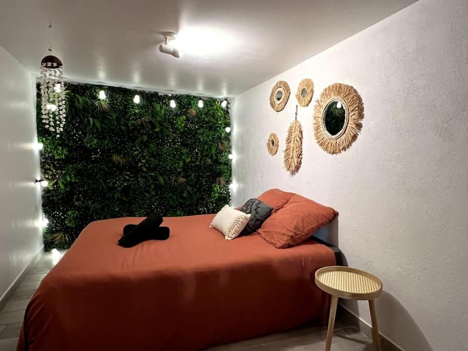 - une chambre avec un lit rouge et une haie verte dans l'établissement Hyper centre - proche Castillet, à Perpignan