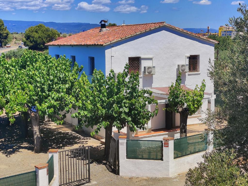 una casa bianca con degli alberi di fronte di Villa Elena a Salou