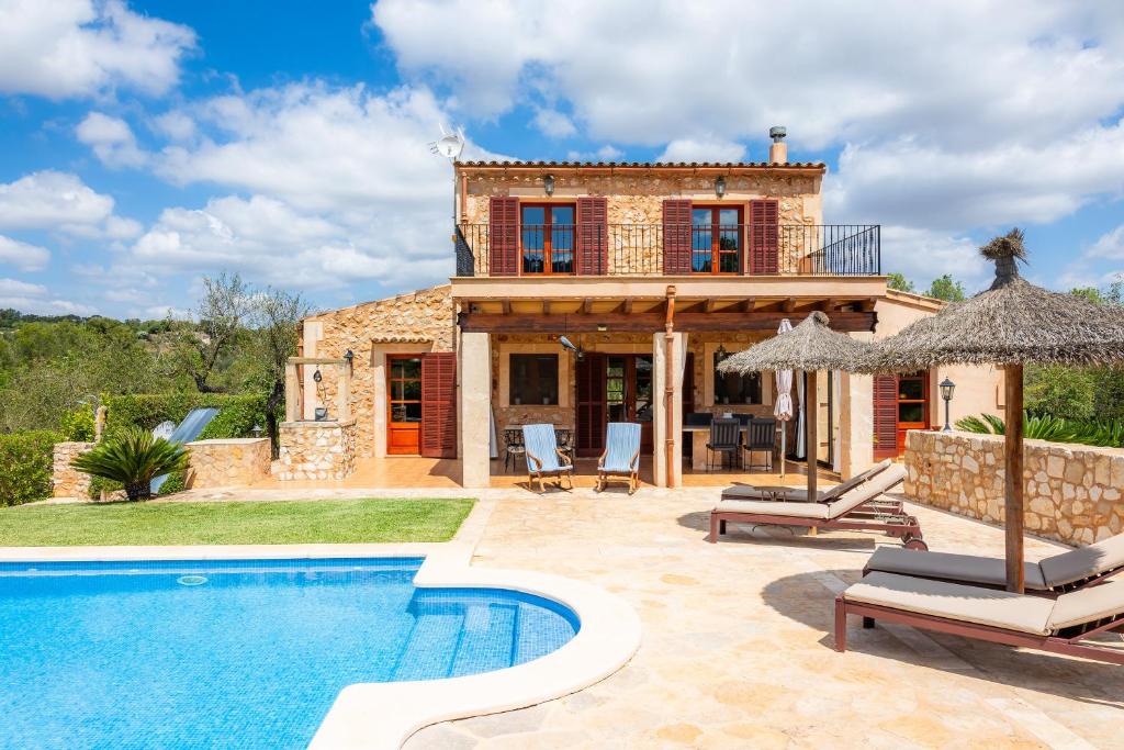 a villa with a swimming pool in front of a house at Es Turó de Son Mel in Petra