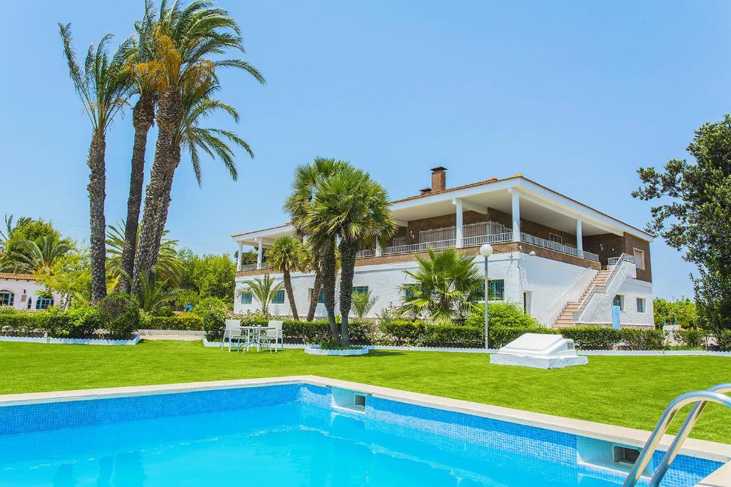 uma casa grande com piscina e palmeiras em 250 Finca CODOVI - Alicante Holiday em Los Montesinos