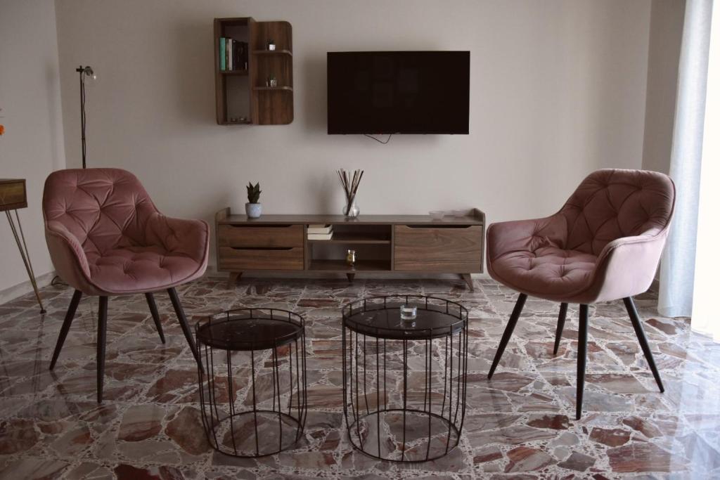 un soggiorno con 2 sedie e una TV di Russo Apartment a Termoli