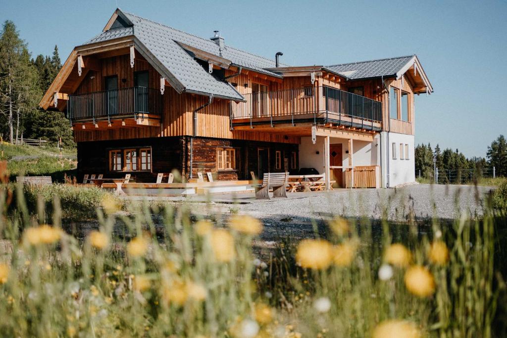 duży drewniany dom na środku pola w obiekcie Chalet Knappenhütte w Villach